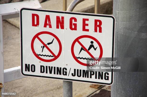 'danger: no swimming/jumping' sign near a jetty - kiama stock-fotos und bilder