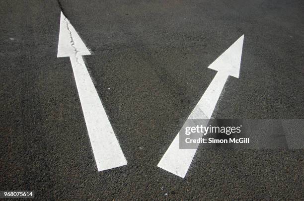 two arrows pointing in different directions on a road - road trip australia stockfoto's en -beelden