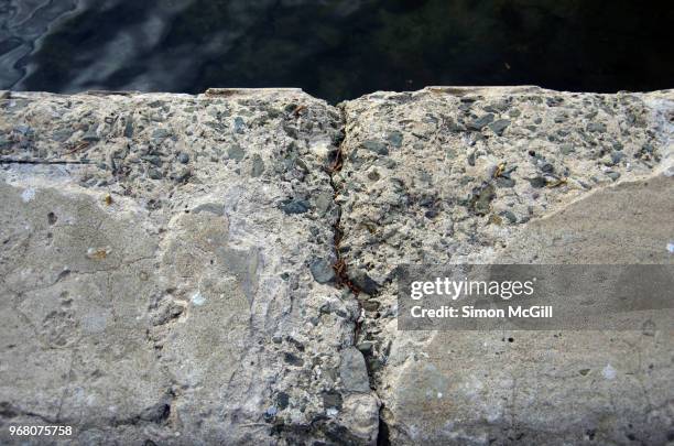 damaged concrete on the edge of a seaside footpath - kiama stock-fotos und bilder