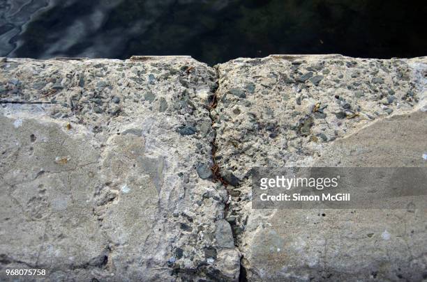 damaged concrete on the edge of a seaside footpath - kiama australia stock pictures, royalty-free photos & images