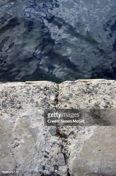 damaged concrete on the edge of a seaside footpath - kiama stock-fotos und bilder