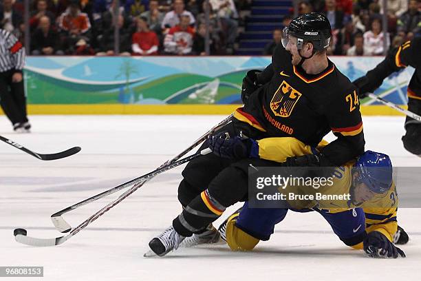 Andre Rankel of Germany and Tobias Enstrom of Sweden battle for the puck in the second period during the ice hockey men's preliminary game on day 6...