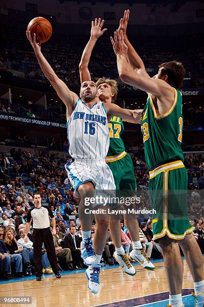 Peja Stojakovic of the New Orleans Hornets shoots around Mehmet Okur and Andrei Kirilenko of the Utah Jazz on February 17, 2010 at the New Orleans...