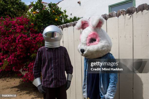 boys in backyard wearing space helmut and bunny mask - surrealism stock pictures, royalty-free photos & images