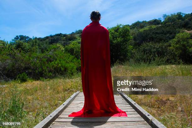 man standing on wooden bridge wearing superhero cape - cape verde fotografías e imágenes de stock
