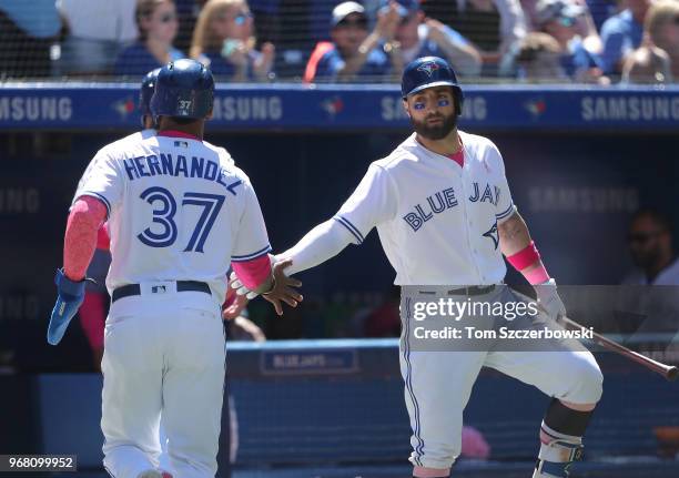 Teoscar Hernandez of the Toronto Blue Jays is congratulated by Kevin Pillar after scoring on a two-run double by Justin Smoak in the fifth inning...