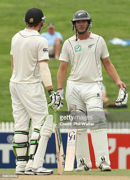 Tim McIntosh and Martin Guptill of New Zealand await the 3rd umpires decision on the runout of Tim McIntosh during day four of the First Test match...