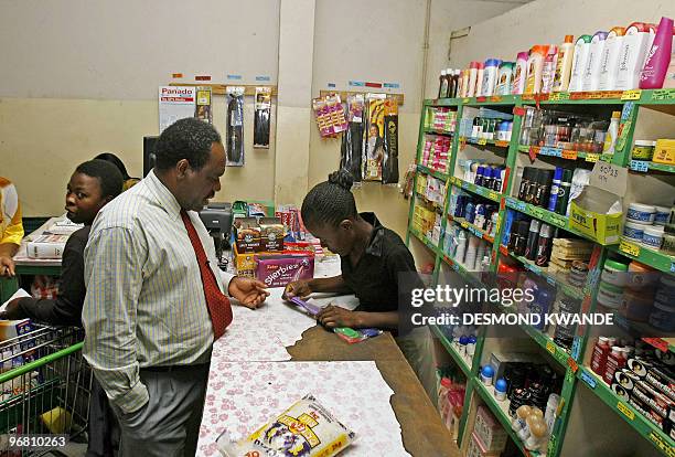 Zimbabwe-politics-anniversary-economy,FEATURE, by Charlotte Plantive John Dzvinamurungu choses products in a supermarket in Zimbabwe's capital Harare...