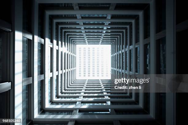 looking up from the patio of a public apartment building - square interior stock pictures, royalty-free photos & images