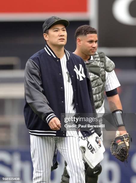 Pitcher Masahiro Tanaka and catcher Gary Sanchez of the New York Yankees make the walk from the bullpen to the dugout to start pitching in an MLB...