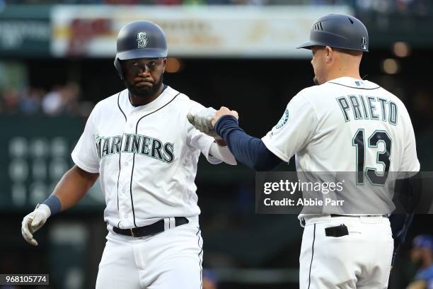 Denard Span high fives Chris Prieto of the Seattle Mariners after hitting a single in the second inning against the Texas Rangers during their game...