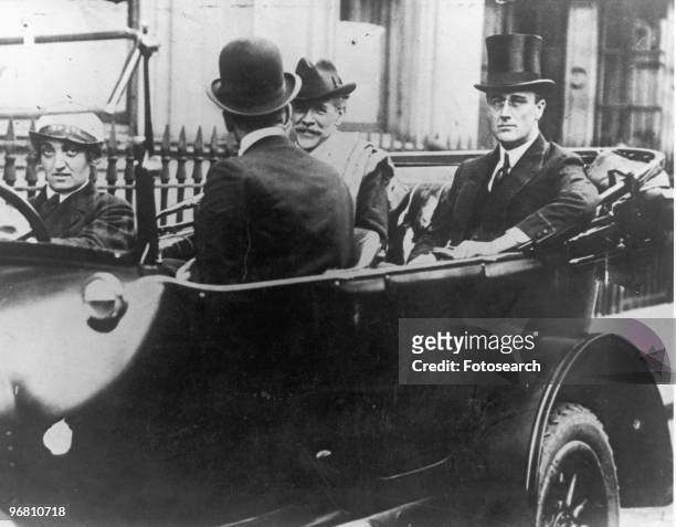 President Franklin D. Roosevelt seated with friends in an open car, circa 1930s. .