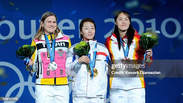 Jenny Wolf of Germany poses after winning the silver, Lee Sang-Hwa of South Korea the gold and Wang Beixing of China the bronze medal during the...