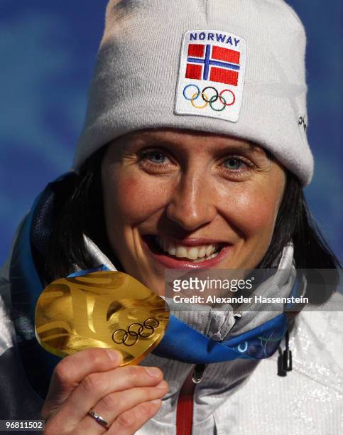 Marit Bjoergen of Norway celebrates with her gold medal during the medal ceremony for the Ladies' Individual Sprint Cross-Country on day 6 of the...