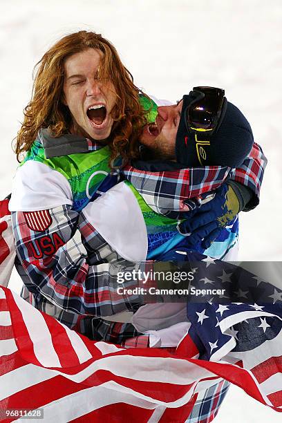 Shaun White of the United States reacts with fellow American Scott Lago after White wins the gold medal and Lago the bronze in the Snowboard Men's...