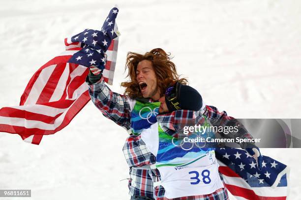 Shaun White of the United States reacts with fellow American Scott Lago after White wins the gold medal and Lago the bronze in the Snowboard Men's...