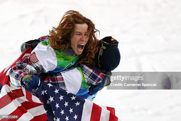 Shaun White of the United States reacts with fellow American Scott Lago after White wins the gold medal and Lago the bronze in the Snowboard Men's...