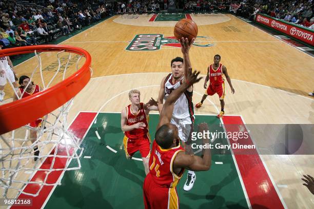 Carlos Delfino of the Milwaukee Bucks shoots a layup against Carl Landry of the Houston Rockets on February 17, 2010 at the Bradley Center in...