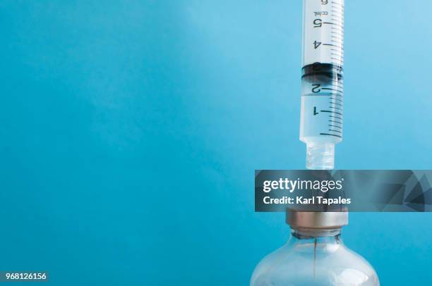 a syringe is injected into a vial - インフルエンザワクチン ストックフォトと画像