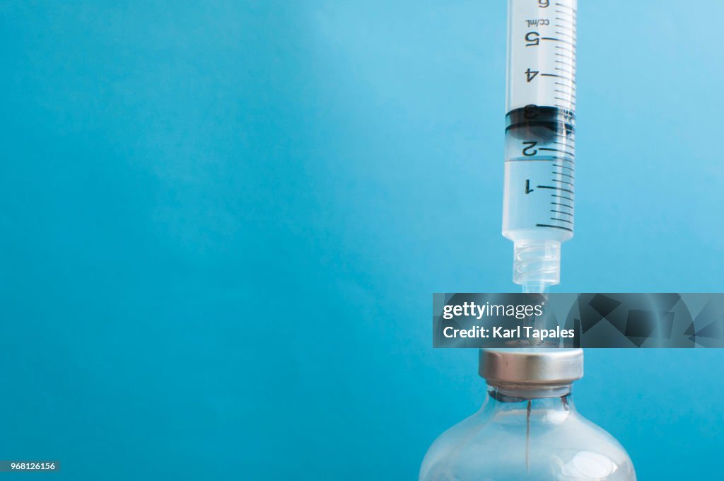 A syringe is injected into a vial