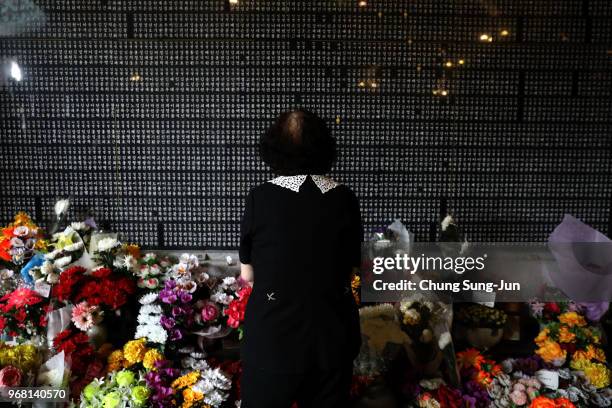 South Korean woman watchs engraved name of her older brother who died during the Korean War at Seoul National Cemetery on June 6, 2018 in Seoul,...