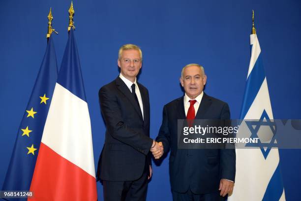 Israel's Prime Minister Benjamin Netanyahu is welcomed by French Economy Minister Bruno Le Maire at the French Economy Ministry in Paris on June 6,...