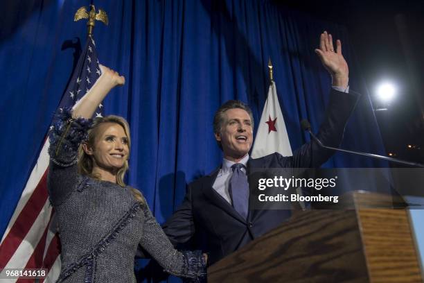 Gavin Newsom, Democratic candidate for governor of California, right, and his wife Jennifer Siebel Newsom, wave to attendees during a primary...