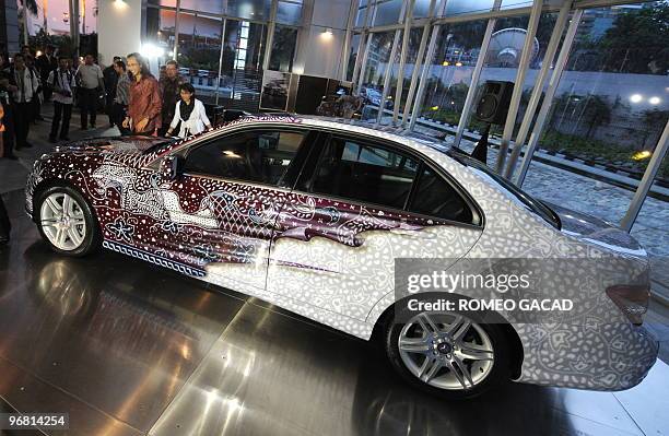 Popular Indonesian musician Satriyo "Piyu" Yudi Wahono stands next to his Mercedes-Benz C 250 Batik version during a handover ceremony at a Jakarta...