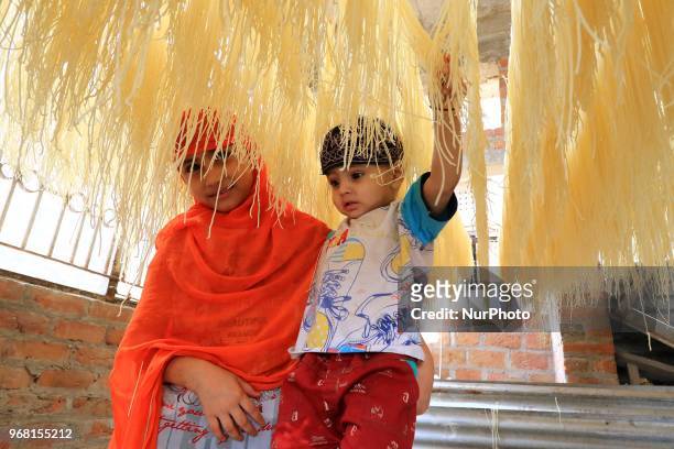 An Indian Muslim mansoori family's kids play around dries up traditional sweet dish 'Vermicelli' or 'Sewaiyan' for sale ahead the muslims festival...