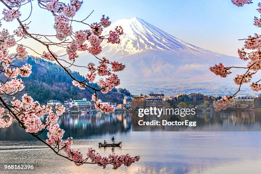 Fisherman sailing boat in Kawaguchiko Lake and Sakura with Fuji Mountain Reflection Background Fisherman sailing boat in Kawaguchiko Lake and Sakura with Fuji Mountain Reflection Background