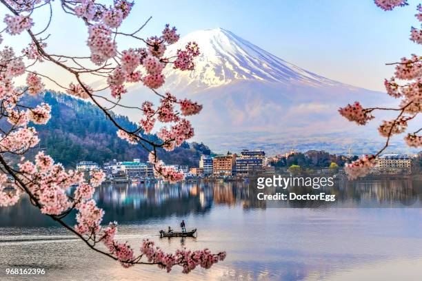 fisherman sailing boat in kawaguchiko lake and sakura with fuji mountain reflection background - giappone foto e immagini stock