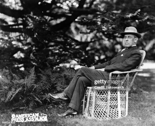 Full length portrait of American President Woodrow Wilson seated outdoors, circa 1920. .