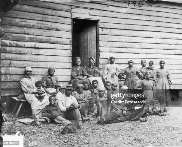 Formerly enslaved people sit at Foller's House in Cumberland Landing, Virginia circa 1850.