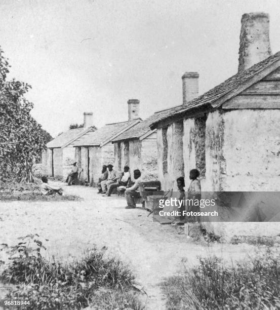 Black enslaved people sit outside of their Quarters in Ft, George Island, Florida circa 1850.