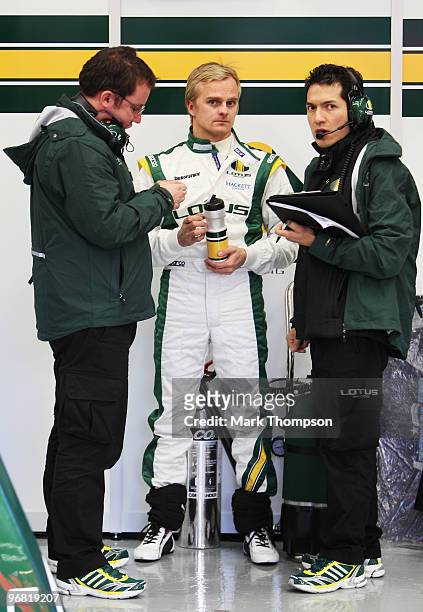 Heikki Kovalainen of Finland and Lotus talks to engineers in his team garage during winter testing at the Circuito De Jerez on February 18, 2010 in...