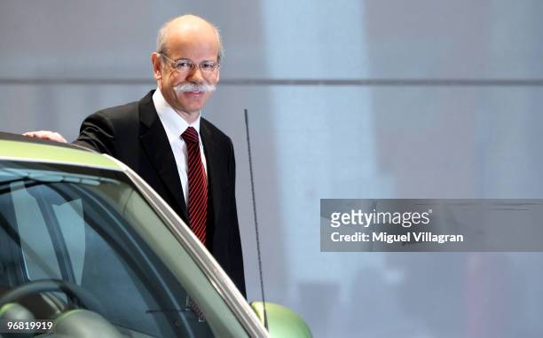 Dieter Zetsche, CEO of Daimler AG, poses next to a smart electric car during the company's annual press conference on February 18, 2010 in Stuttgart,...