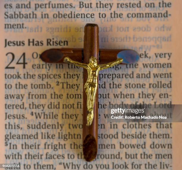 Crucifix over the Bible text which has the 'Jesus Has Risen' passage in the Gospel of Luke. Christian religion themed images.