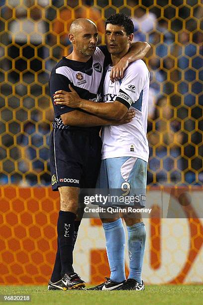 Kevin Muscat of the Victory and John Aloisi of Sydney hug after the A-League Major Semi Final first leg match between the Melbourne Victory and...
