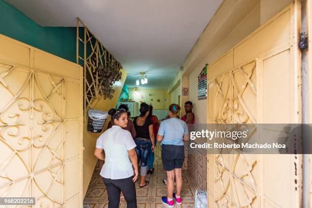 People lining up at a small private business inside a home. They are waiting to buy homemade food.