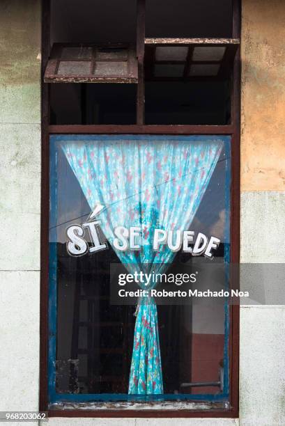 Sign reading" Yes We Can" on a glass window of a government run office. The phrase became popular after Raul Castro used it during the Special Period.