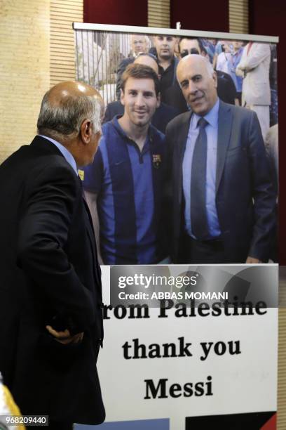 Head of the Palestinian Football Association Jibril Rajoub stands in front of a sign addressed to Argentina's star player Lionel Messi during a press...