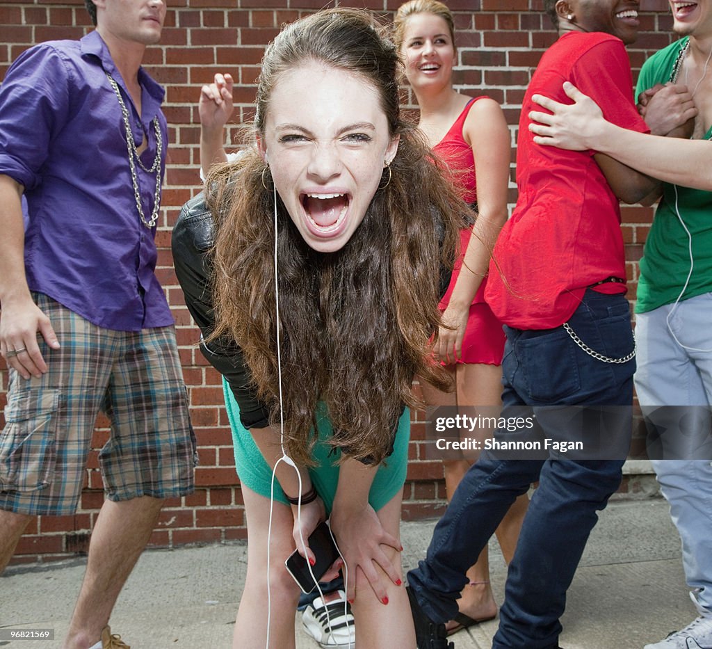 Teenage girl screaming with friends in background