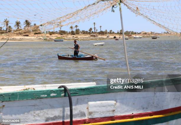 Fisherman stands on his wooden boat at the Mediterranean sea in Tunisia's Kerkennah Islands off Sfax on June 5, 2018. - More than 65 migrants drowned...