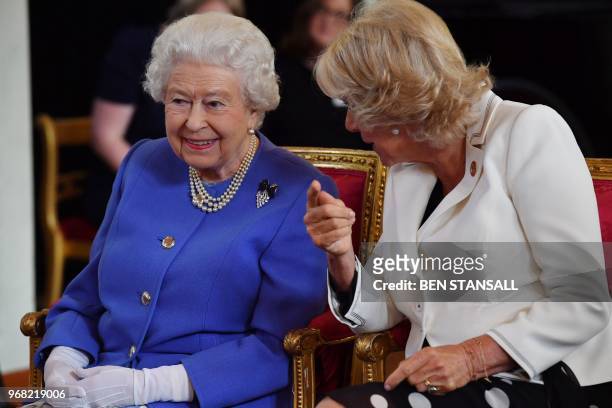 Britain's Queen Elizabeth II speaks with Britain's Camilla, Duchess of Cornwall as they watch a demonstration by dogs of the charity Medical...
