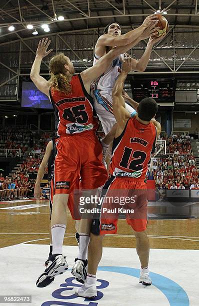 Chris Goulding of the Blaze lays up over Luke Schenscher and Kevin Lisch of the Wildcats during game one of the NBL semi final series between the...