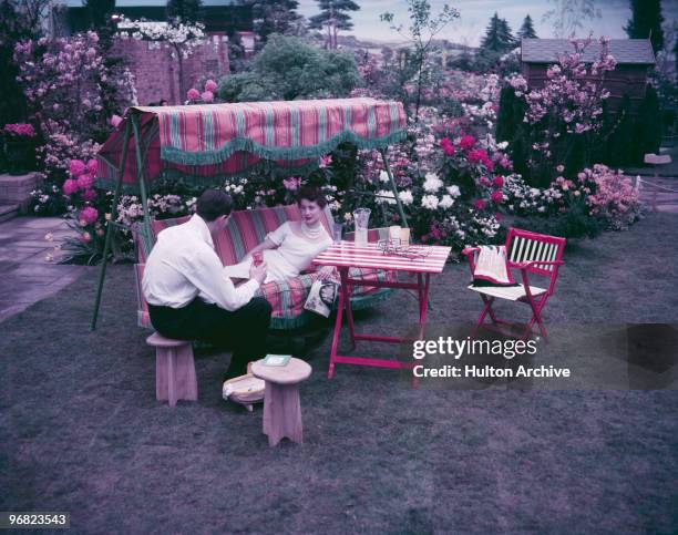 Young couple relaxing in the garden, July 1955.