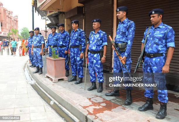 Indian Rapid Action Force personnel stand guard outside shuttered shops during a strike called by Sikh radical groups on the occasion of the 34th...