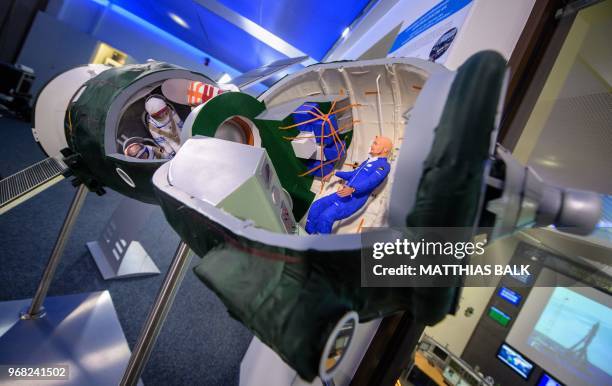 Figurines featuring German astronaut Alexander Gerst and members of his team are placed in a mockup of a Soyuz spacecraft during an event on the...