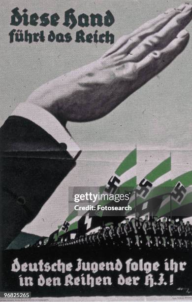 Poster of a Nazi Salute with Hitler Youth Marching in the background circa 1915. Text 'This Hand Guides The Reich' 'German Youth Follow it in the...