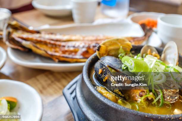 korean traditional seafood stew and fried mackerel at background - sungjin kim stock pictures, royalty-free photos & images